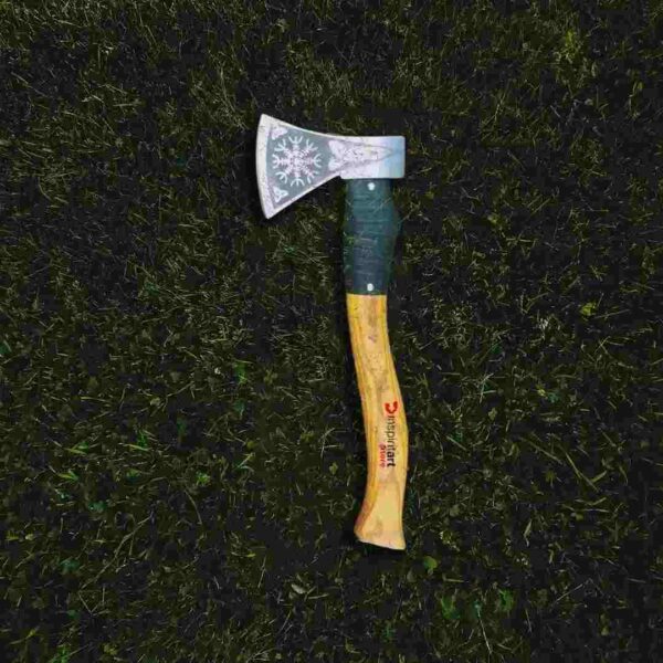 A wooden Hudson-Bay axe is laying on the grass.